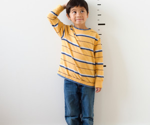 Boy standing against a height chart