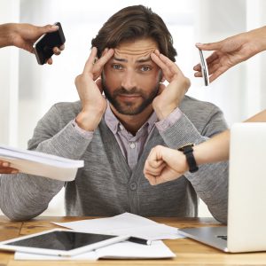Nobody thought of bringing a headache pill to the party? A cropped shot of a handsome businessman under strain as colleagues request various things from him